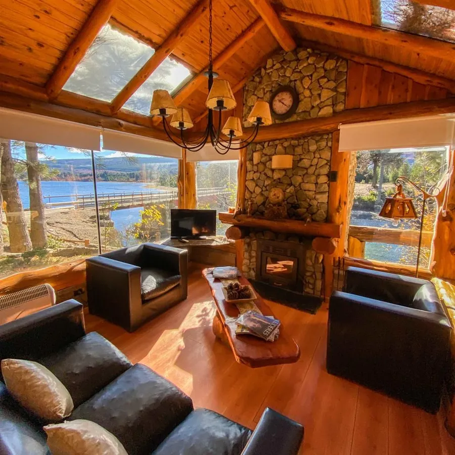 Living con hogar a leña y ventanales al lago