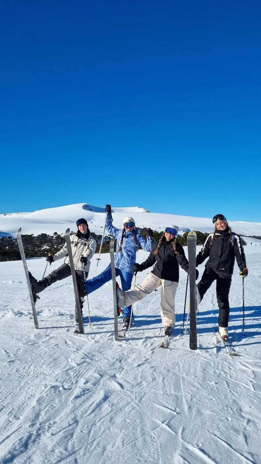 Grupo familiar con cascos y esquís en la nieve
